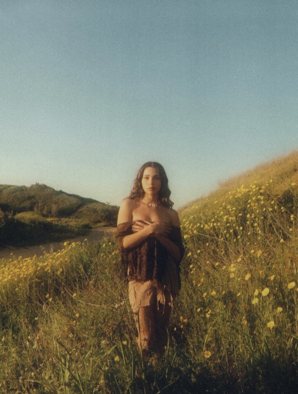 Golden hour — figure standing in a field of wildflowers