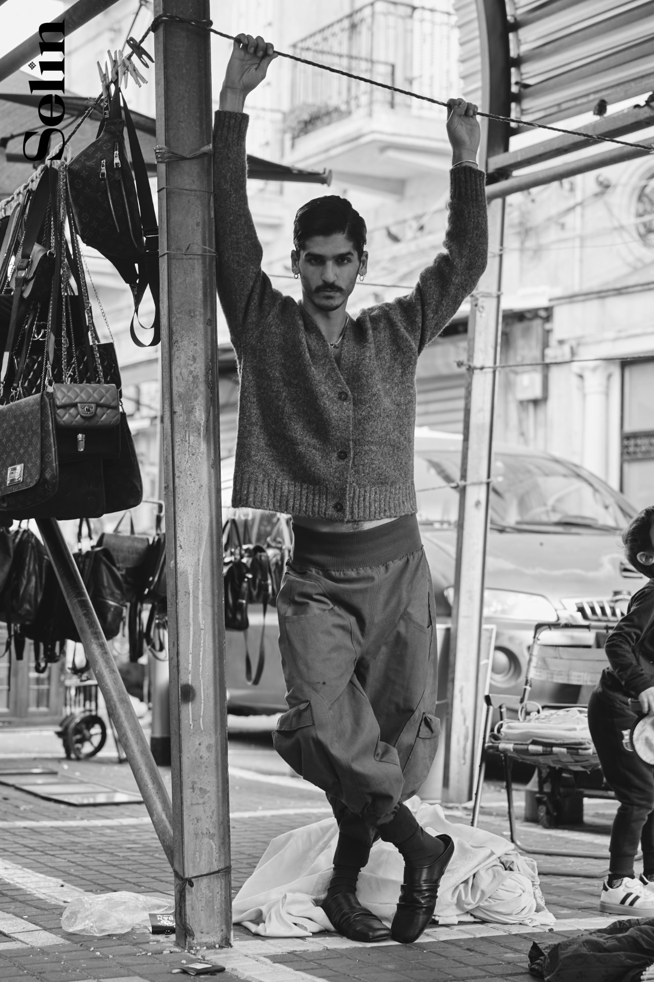 SELIN — model holding a market line overhead in a wool cardigan