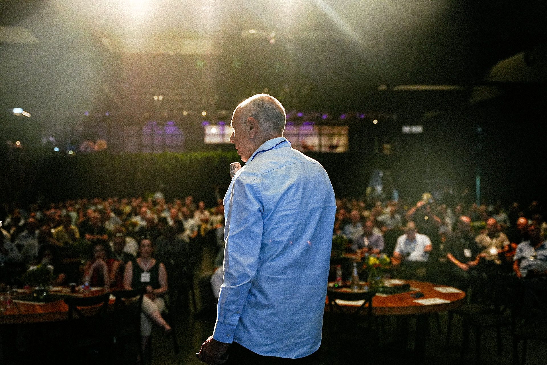 2025 Economic Conference — speaker on stage facing a seated audience