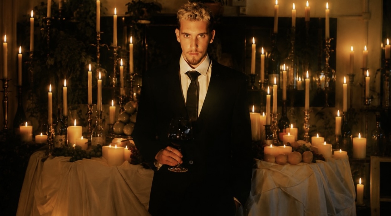 Candlelit portrait — suit and a glass of wine among candelabras